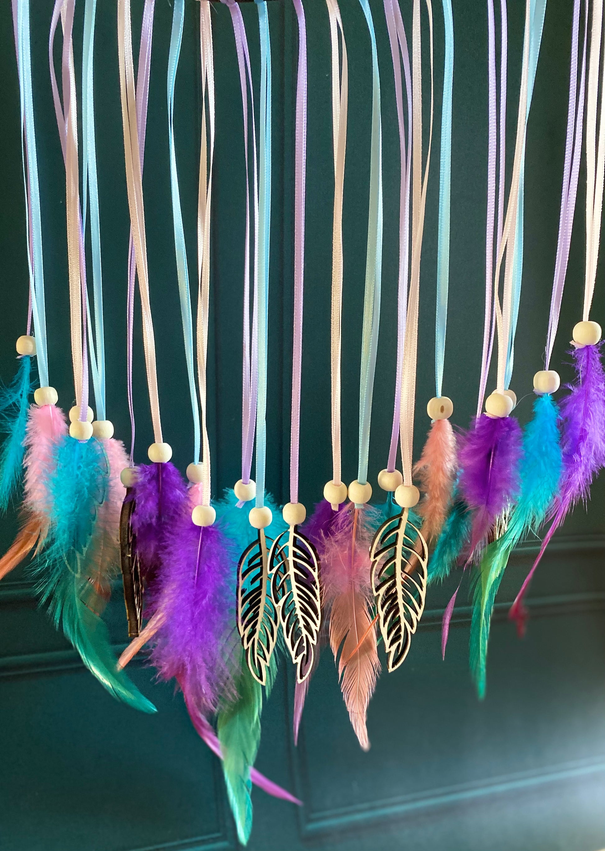 zoom sur les rubans colorés et plumes suspendues du cercle attrape-rêves